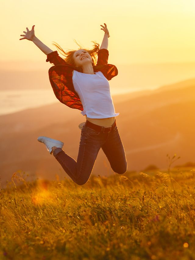 girl jumping in the air in a field