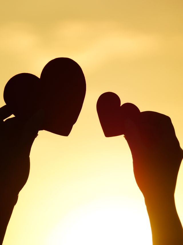 hands holding heart with sunset