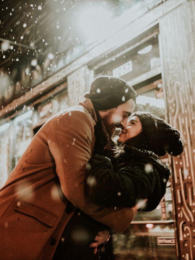 a happy couple hugging in the snow