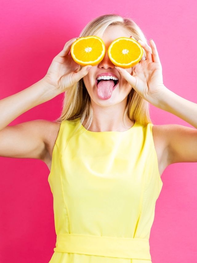 woman using an orange for eyes