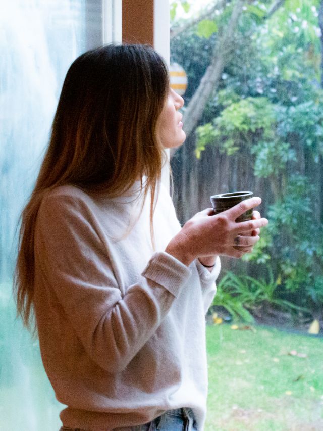 woman drinking coffee at window