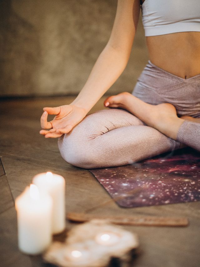 woman meditating with candles