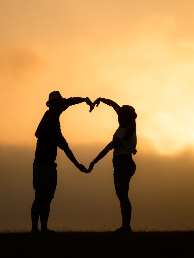 a couple making heart shape with arms