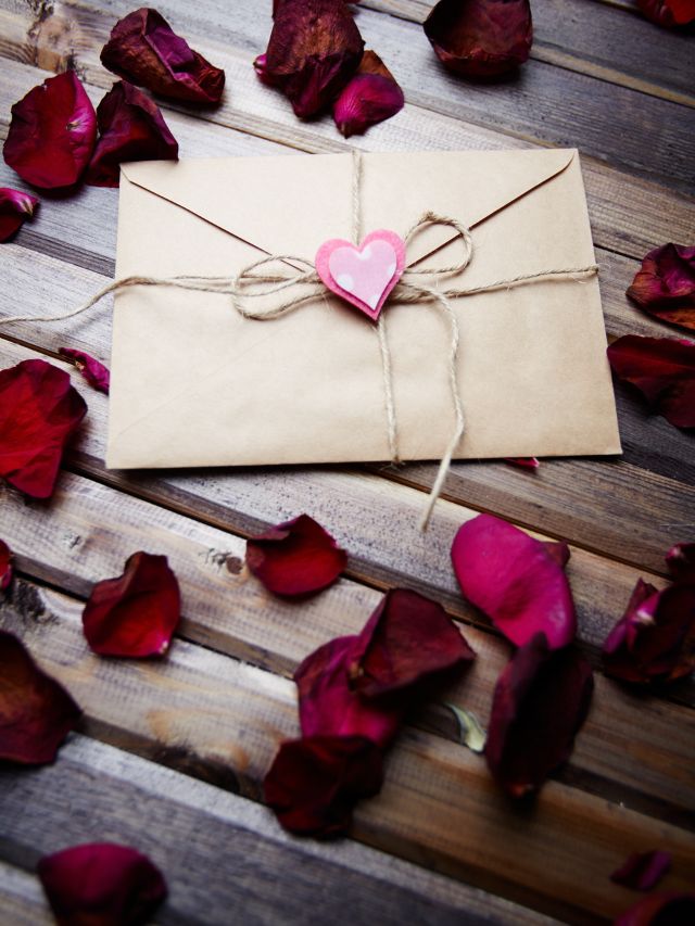 letter of love with pink heart and rose petals