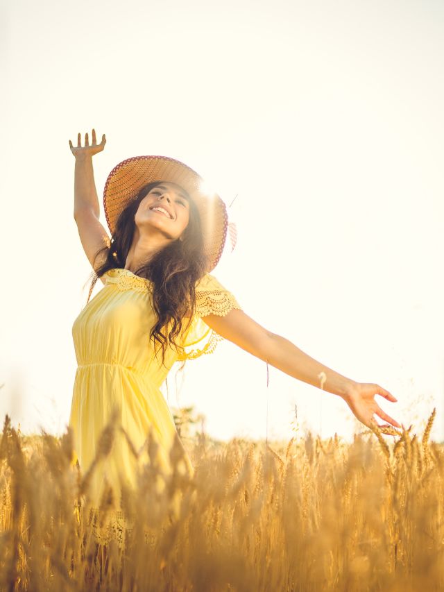 happy young women with arms open in field