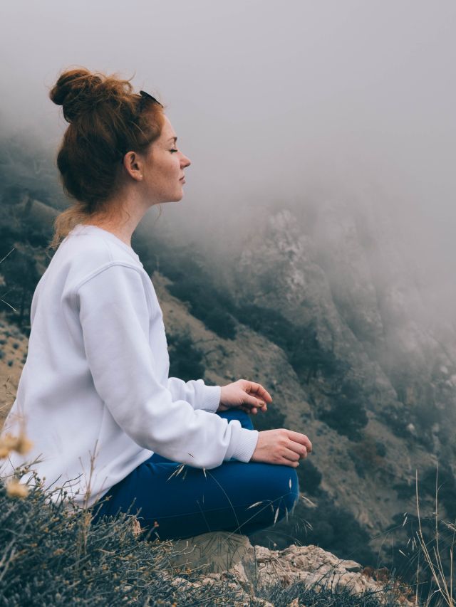 woman meditating in the mountains