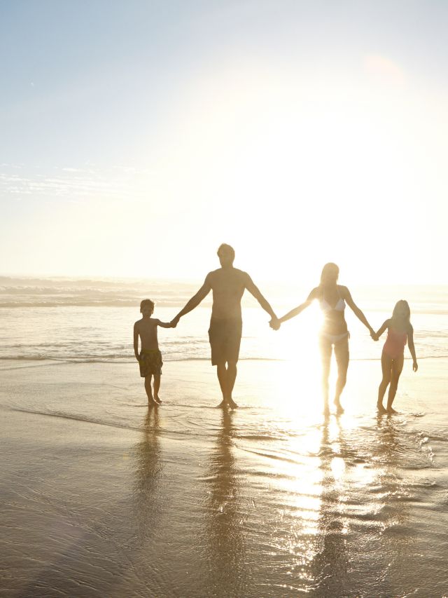 family walking on the beach hand in hand