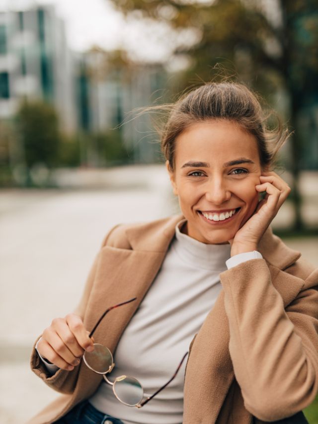 woman smiling on bench in city