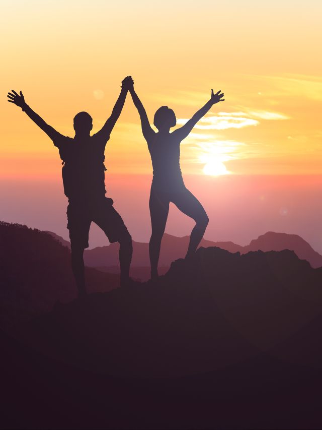 couple standing on mountain with sunset