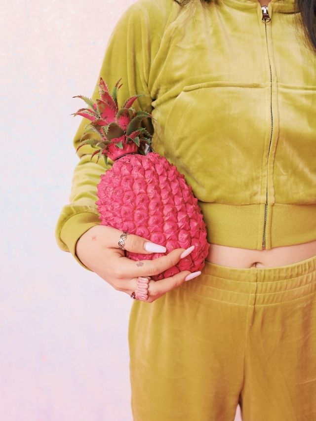 woman holding a pink pineapple