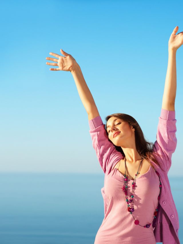 woman enjoying life with her arms up in the air