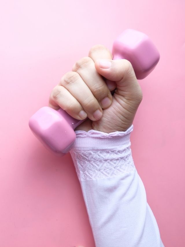woman arm holding a pink weight