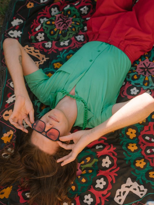 woman lying on carpet with glasses