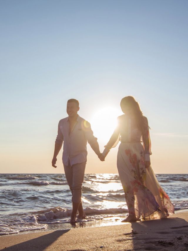couple walking on the beach together holding hands