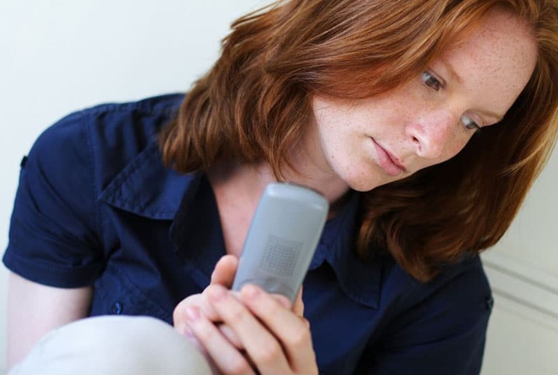 woman with a cellphone sitting on the floor