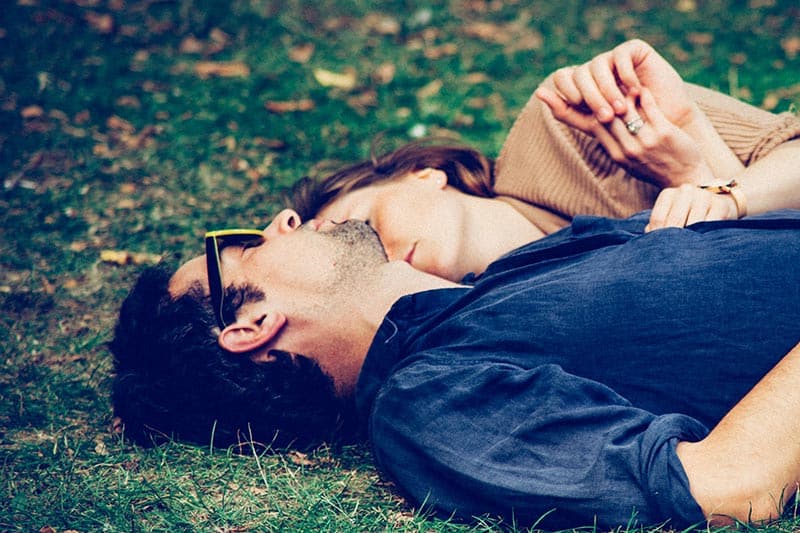 Man and woman lying on grass hugging