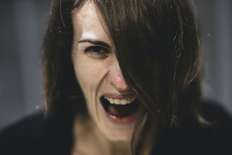 an angry woman half of the face covered with hair focused