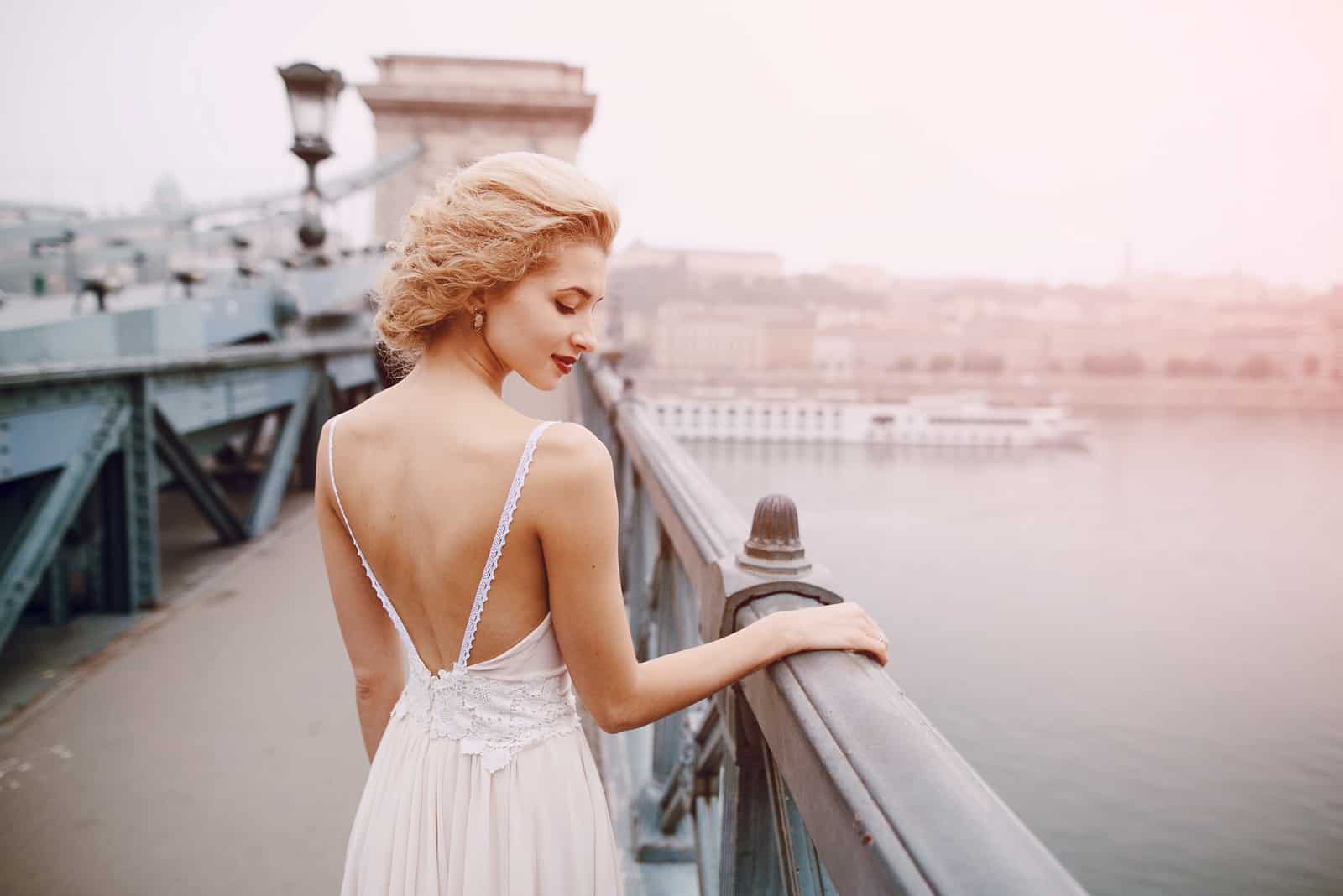 a woman with short blonde hair stands on the bridge