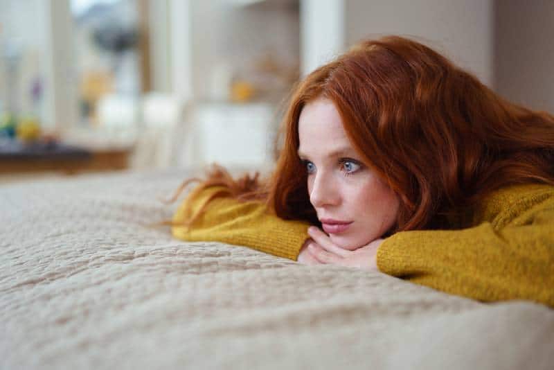 young women lying on her bed thinking and resting