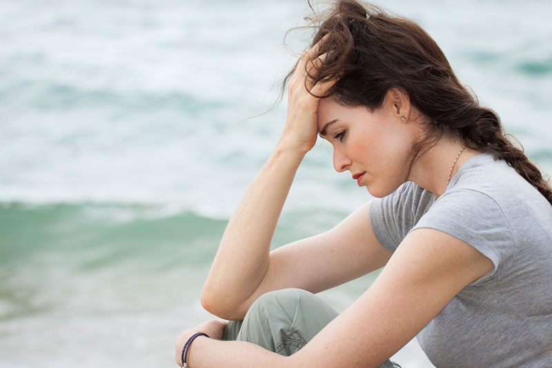 sad woman sitting near the sea