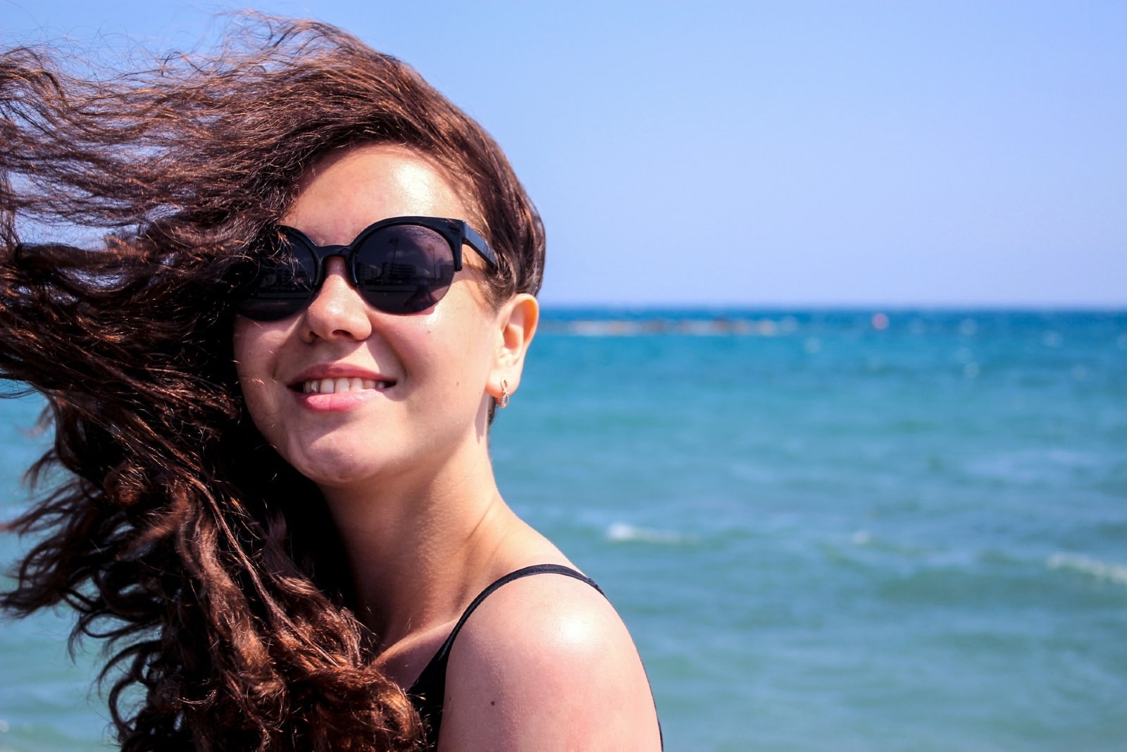 woman with sunglasses standing near sea