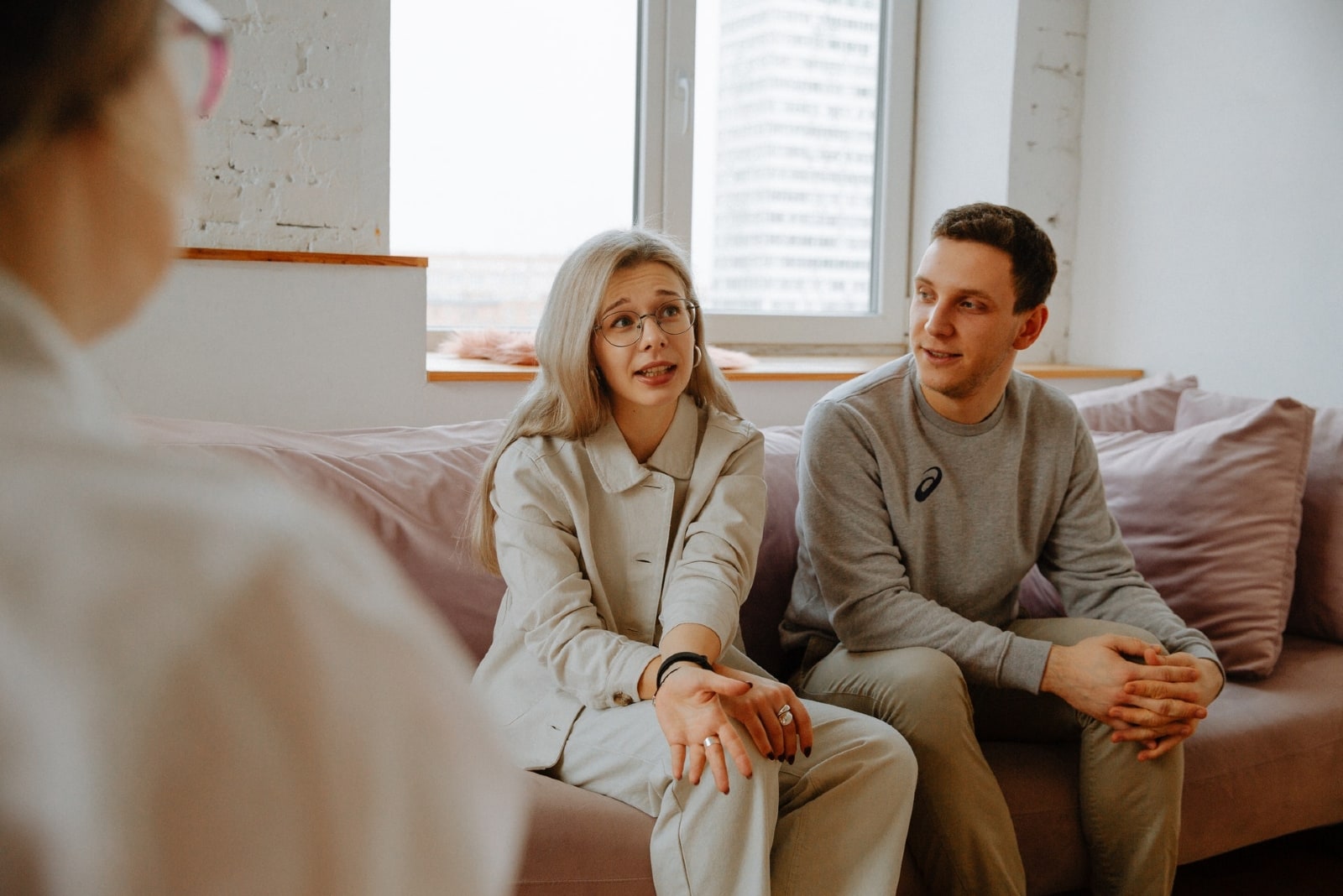 woman talking to therapist while sitting near man